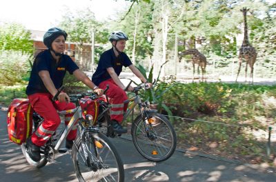 Zwei FSJler fahren auf Fahrrädern durch den Kölner Zoo